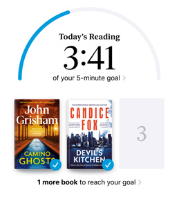 iPhone screen showing the Reading Goals interface in the Books app. At the top, there is a progress ring for a reading goal. Below the progress ring are three book covers. Beneath the book covers is text that one more book is needed to reach the 2024 goal of reading eight books.