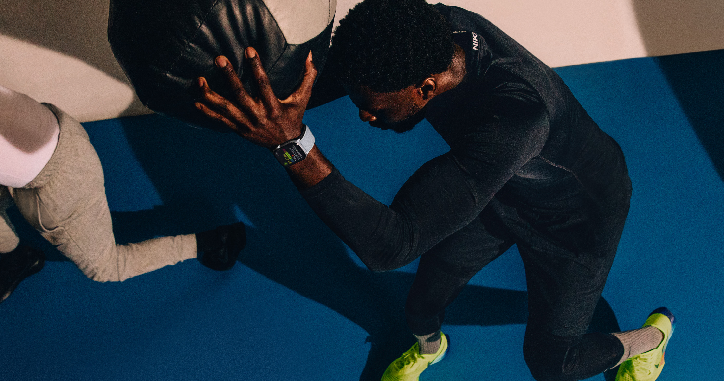 Un homme s’entraîne avec un ballon d’exercice; il porte une Apple Watch Series 10.