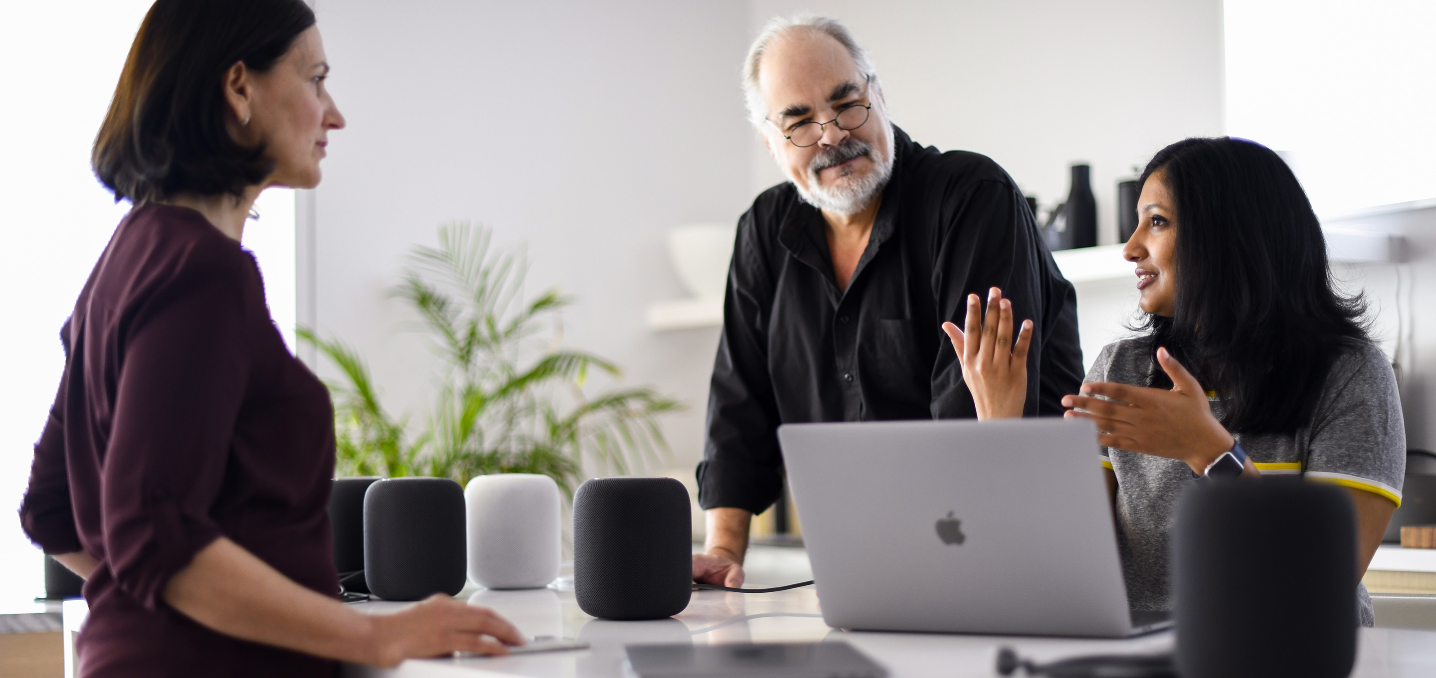 Un grupo de empleados del equipo de inteligencia artificial y aprendizaje automático de Apple hablando en una oficina.