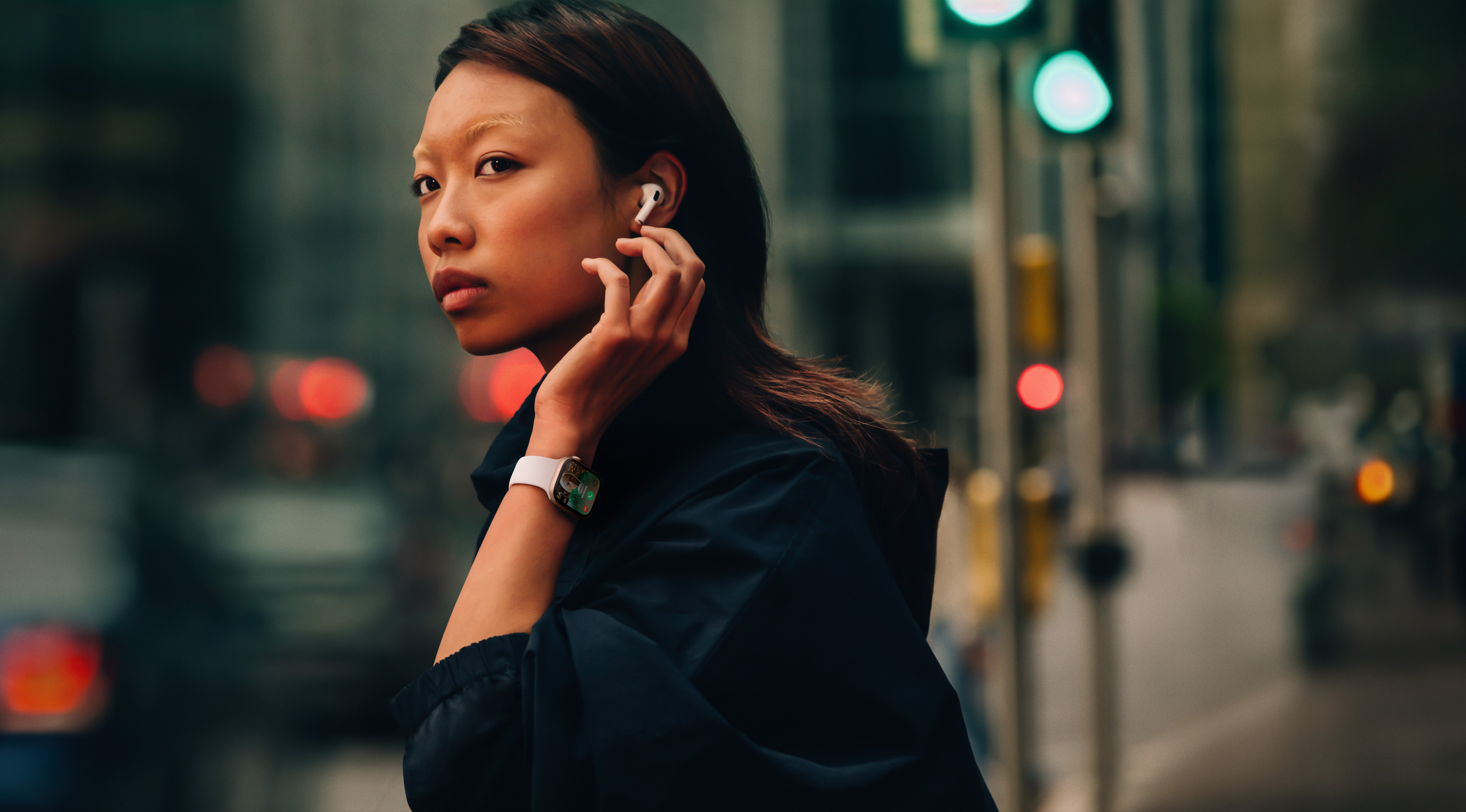 Жінка на вулиці з Apple Watch Series 10 та AirPods.