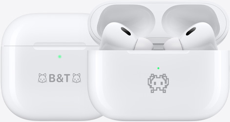 Two AirPods 4 charging cases engraved with example emojis: one with a cat emoji on either side of the text B&T, and another with a crab emoji